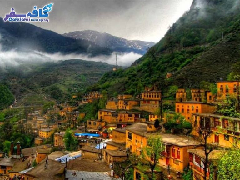 تصویری از خانه‌های زرد رنگ و پلکانی روستای ماسوله در مه، مناسب برای راهنمای سفر به ماسوله
