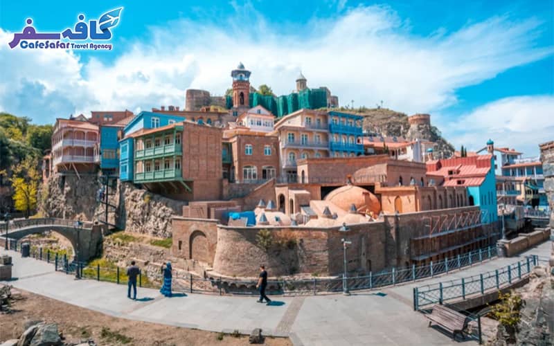 تصویری از مجسمه مادر گرجستان بر فراز تپه، با نمای شهر تفلیس در پس‌زمینه، مناسب برای پکیج‌های تور تفلیس